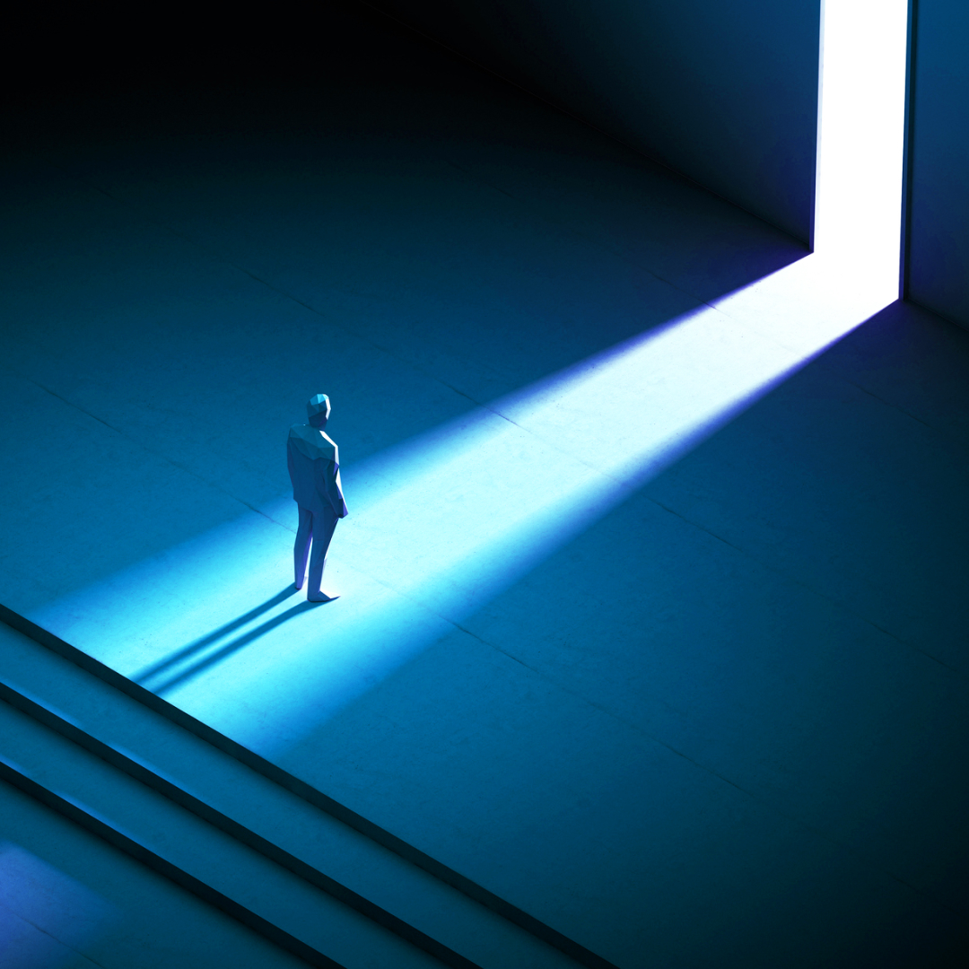 Une personne seule se tient dans une pièce sombre avec des escaliers derrière elle. Ils sont éclairés par une lumière bleue qui passe par une porte ouverte, projetant une longue ombre.
